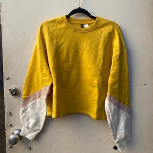 New H&M divided yellow cropped sweatshirt. Size medium.